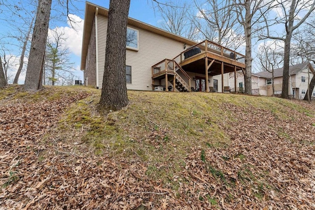 rear view of house featuring central AC, a lawn, and a deck