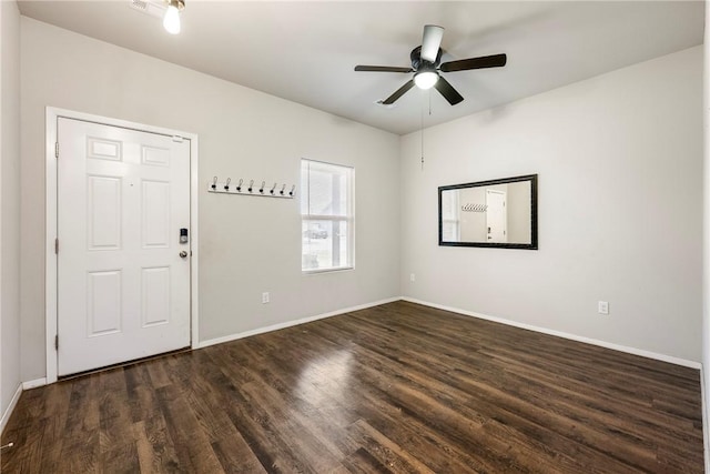 empty room featuring ceiling fan, dark wood-style flooring, and baseboards