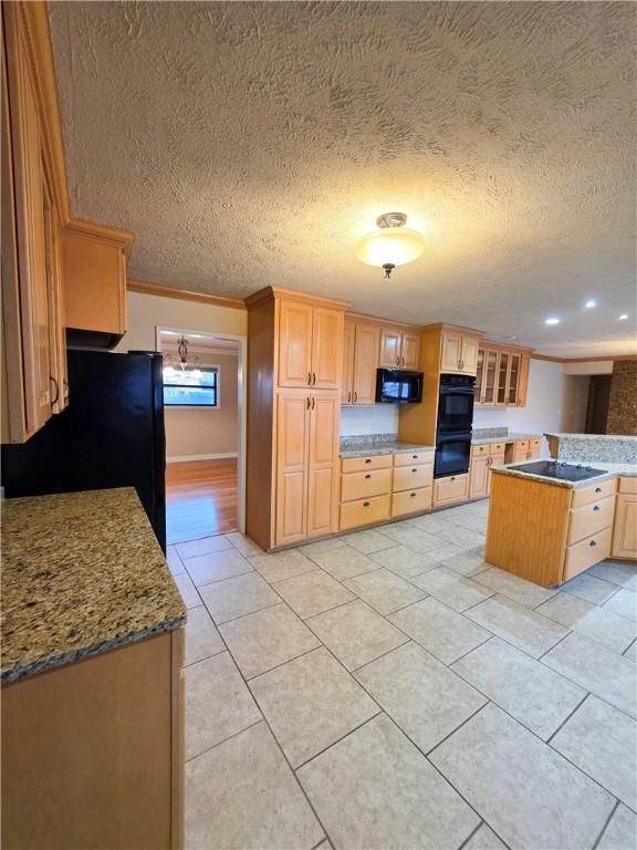 kitchen featuring light stone counters, light tile patterned floors, black appliances, and light brown cabinets