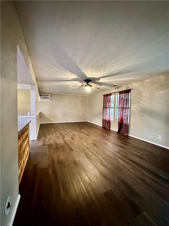 unfurnished living room featuring ceiling fan and dark hardwood / wood-style flooring