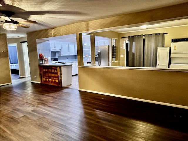 kitchen featuring white cabinets, stainless steel fridge, dark hardwood / wood-style flooring, stove, and ceiling fan