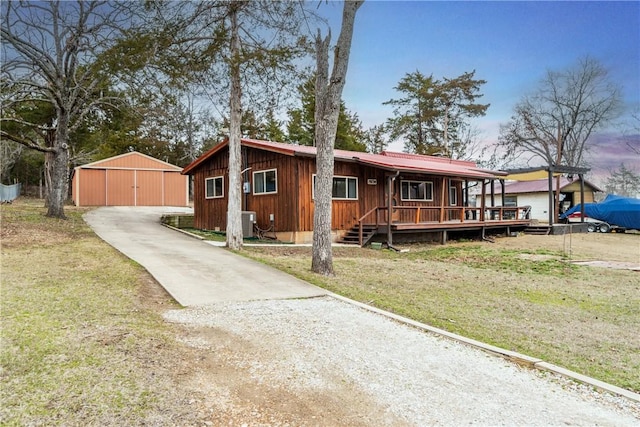 view of front facade featuring a front yard, metal roof, and an outdoor structure