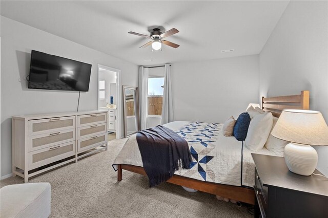 carpeted bedroom with ceiling fan and ensuite bath