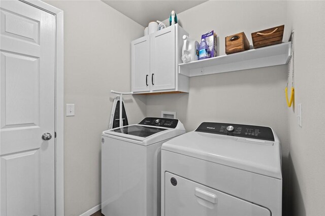 washroom featuring washer and clothes dryer and cabinets