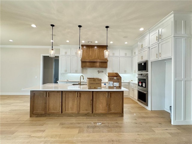 kitchen featuring custom exhaust hood, double oven, white cabinets, a sink, and built in microwave