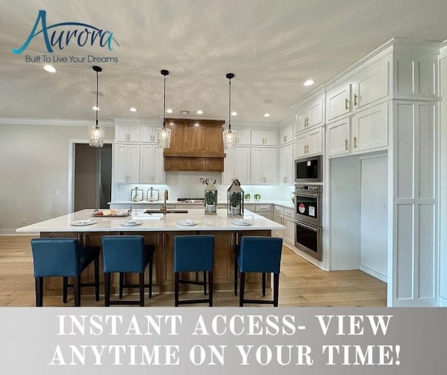 3905 SW Centric Ave, Bentonville, AR 72713 - kitchen with appliances with stainless steel finishes, white cabinets, a sink, light wood-style flooring, and a kitchen bar