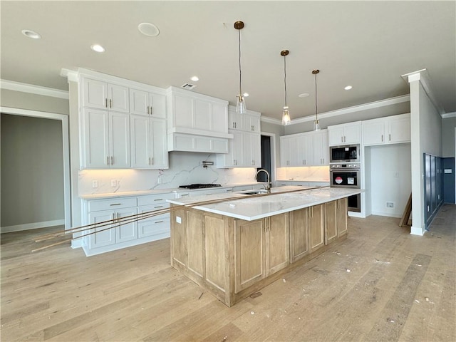 kitchen featuring ornamental molding, stainless steel appliances, light countertops, light wood-type flooring, and a sink