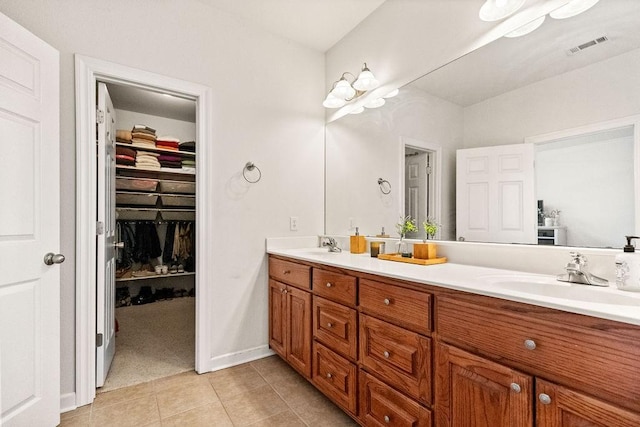 full bath with tile patterned flooring, double vanity, and a walk in closet