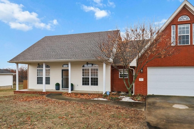 view of front facade with a porch, a garage, asphalt driveway, roof with shingles, and brick siding