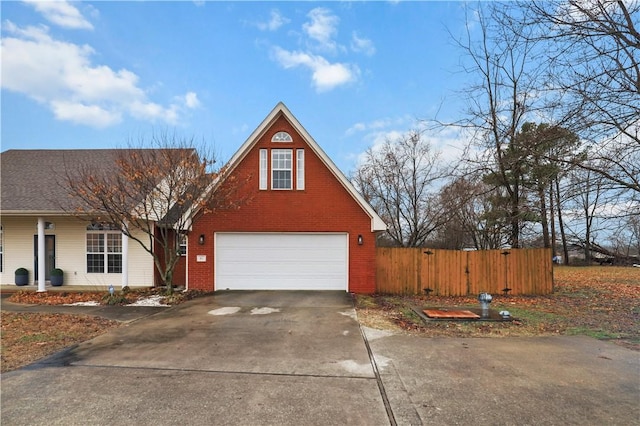 traditional-style house with brick siding, fence, driveway, and an attached garage