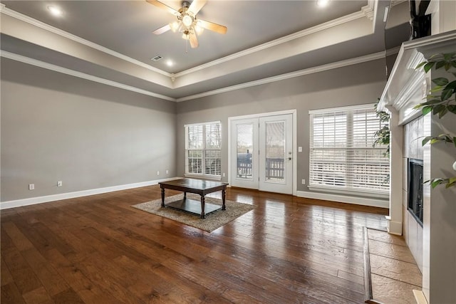 unfurnished living room with hardwood / wood-style flooring, crown molding, and a tray ceiling