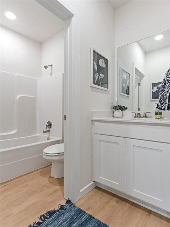 full bathroom with wood-type flooring, toilet, bathing tub / shower combination, and vanity