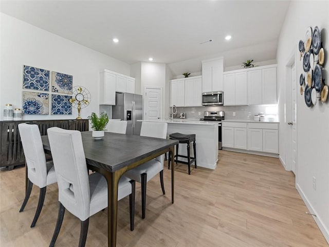 dining area with sink and light hardwood / wood-style flooring