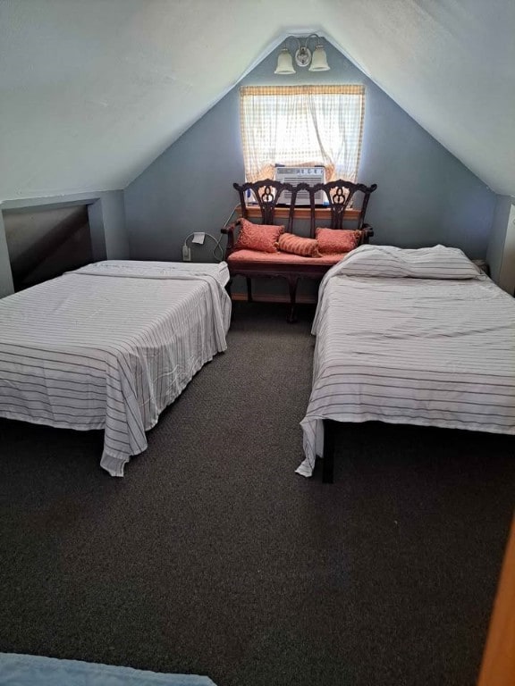 carpeted bedroom with lofted ceiling