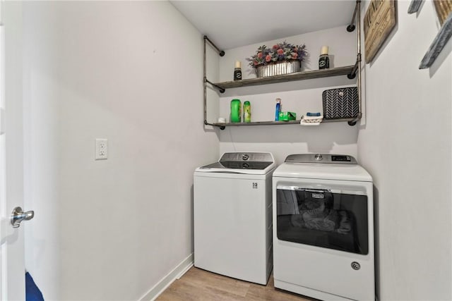 laundry area featuring washer and dryer and light hardwood / wood-style floors