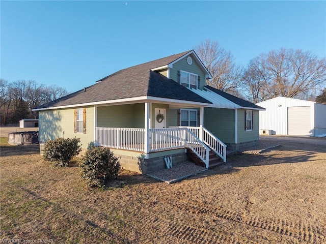 view of front of home featuring a garage, an outdoor structure, and covered porch