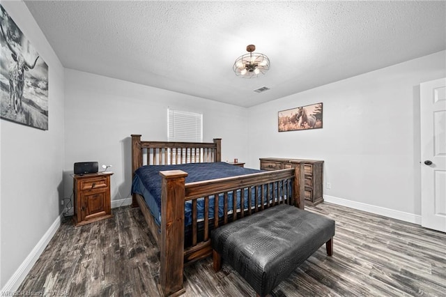 bedroom featuring dark wood-type flooring and a textured ceiling