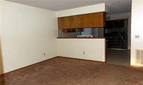 unfurnished living room featuring dark carpet