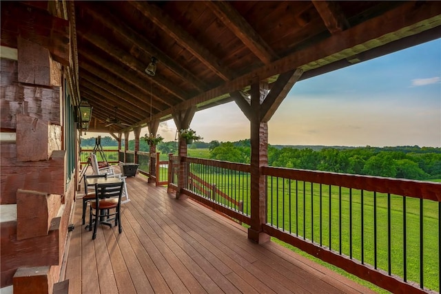 deck at dusk featuring a yard