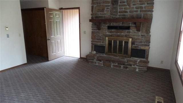 unfurnished living room with dark carpet and a stone fireplace