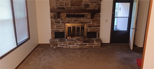 carpeted living room with a stone fireplace