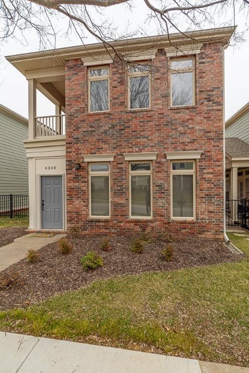 view of front of home featuring a balcony and a front yard