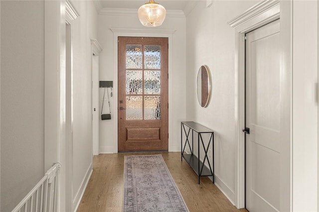 doorway to outside with ornamental molding and light hardwood / wood-style floors