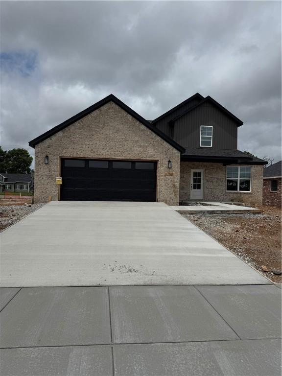 4750 Cowboy St, Springdale, AR 72762 - view of front of home featuring a garage, concrete driveway, and brick siding