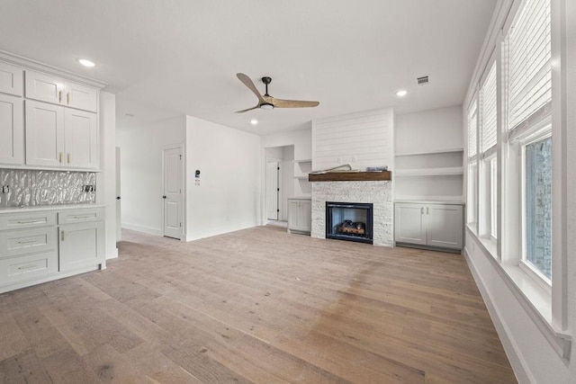 4750 Cowboy St, Springdale, AR 72762 - unfurnished living room with light wood-type flooring, a ceiling fan, recessed lighting, and a stone fireplace
