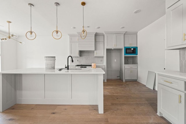 4750 Cowboy St, Springdale, AR 72762 - kitchen featuring light wood finished floors, tasteful backsplash, light countertops, decorative light fixtures, and recessed lighting