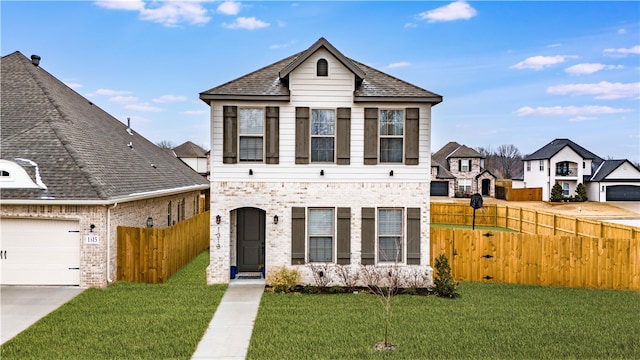 view of front facade with brick siding, fence, and a front lawn