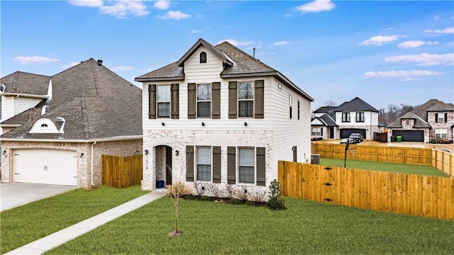 view of front of house with an attached garage, fence, driveway, roof with shingles, and a front yard