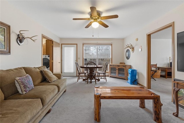 carpeted living room featuring washer / dryer and ceiling fan