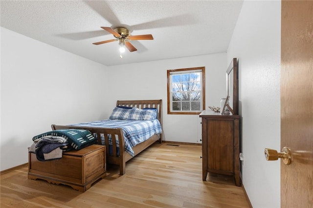 bedroom featuring ceiling fan, a textured ceiling, and light hardwood / wood-style flooring