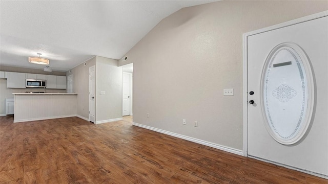 foyer with vaulted ceiling and dark hardwood / wood-style floors