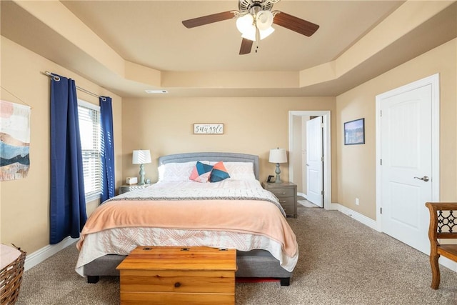 bedroom featuring a tray ceiling, ceiling fan, and carpet flooring