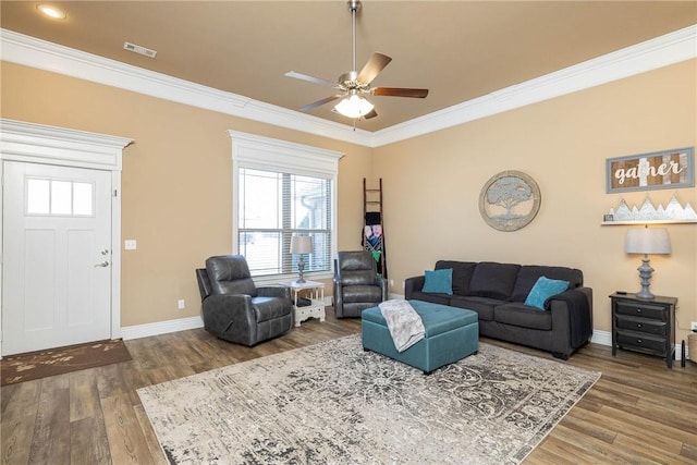 living room featuring wood-type flooring, ornamental molding, and ceiling fan