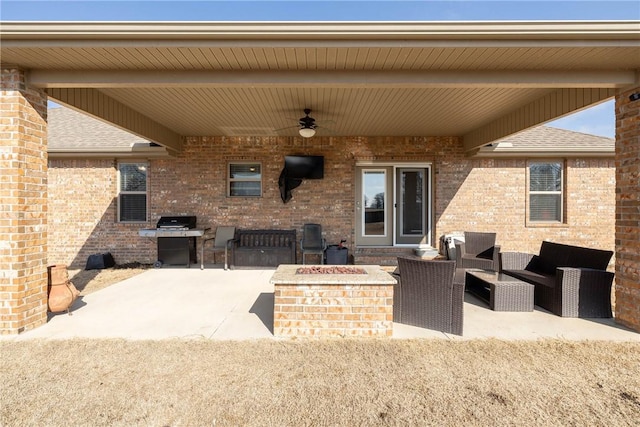 view of patio with ceiling fan, an outdoor living space with a fire pit, and grilling area
