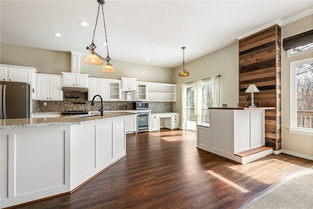 kitchen featuring beverage cooler, a healthy amount of sunlight, a sink, and decorative backsplash