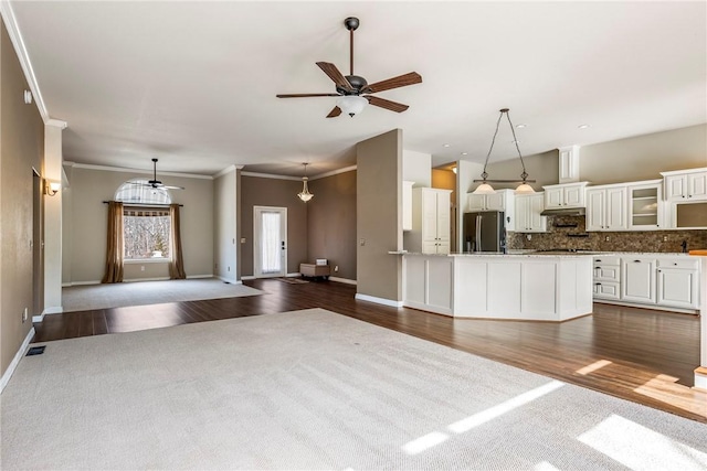 unfurnished living room featuring a ceiling fan, dark wood finished floors, and ornamental molding