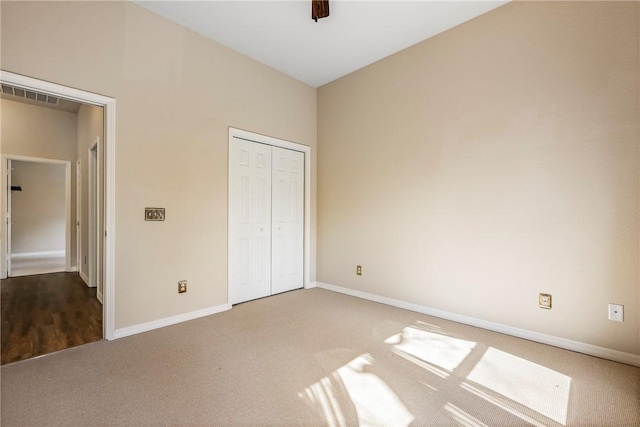 unfurnished bedroom with ceiling fan, visible vents, baseboards, a closet, and carpet