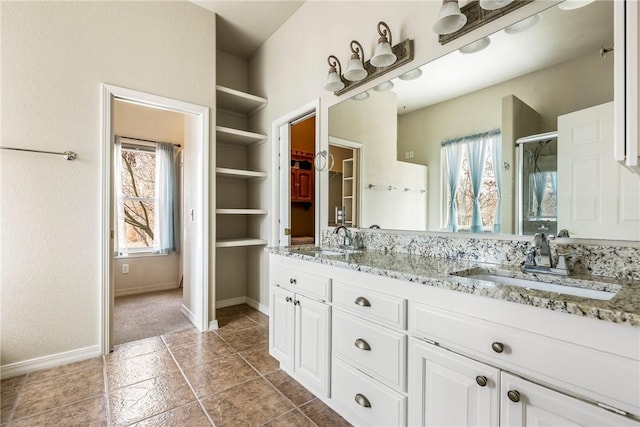 bathroom with a stall shower, a wealth of natural light, and a sink