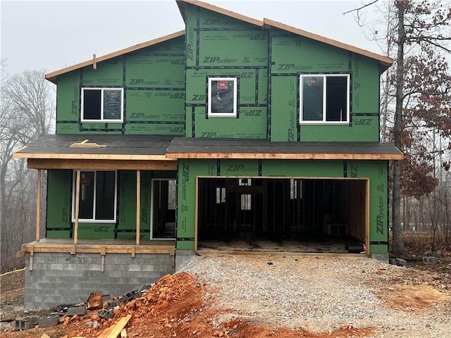 unfinished property featuring a garage and a porch