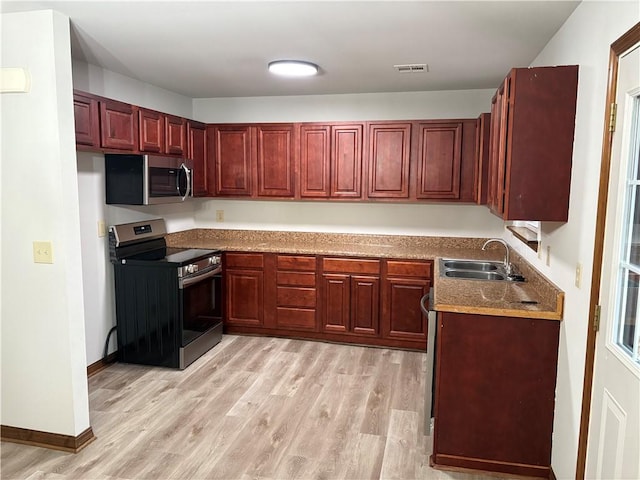 kitchen with sink, light hardwood / wood-style flooring, and appliances with stainless steel finishes