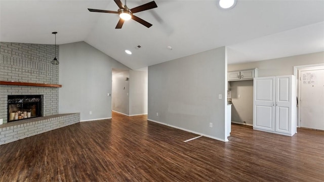 unfurnished living room with lofted ceiling, a brick fireplace, dark hardwood / wood-style floors, and ceiling fan