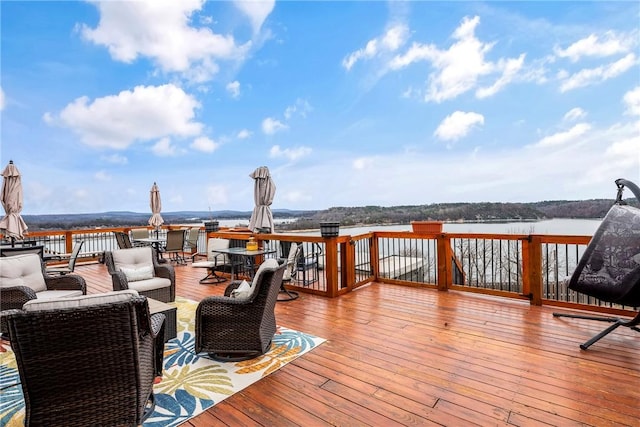 wooden terrace featuring a water view and outdoor lounge area