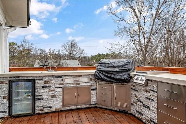 view of patio featuring an outdoor kitchen, area for grilling, beverage cooler, and a deck