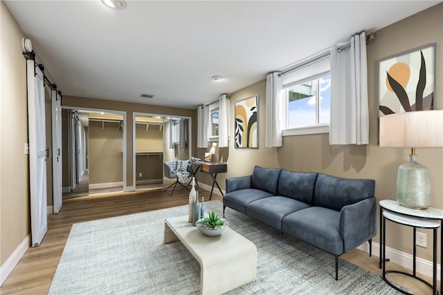 living room featuring a barn door and hardwood / wood-style floors