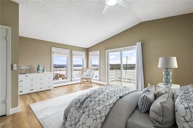 bedroom featuring lofted ceiling, light wood-type flooring, access to outside, ceiling fan, and a textured ceiling