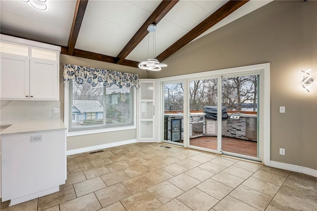 interior space with a healthy amount of sunlight and vaulted ceiling with beams